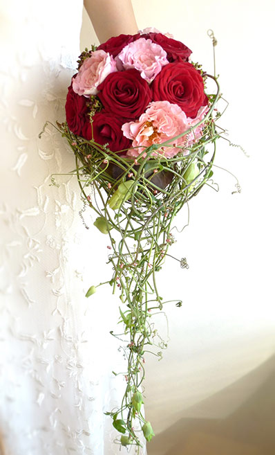 Langer Brautstrauß mit roten Rosen und rosanen Nelken